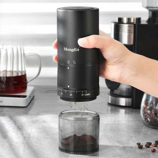 Elektrische Kaffeemühle mit externer Mahlgradeinstellung in der Hand – ideal für präzises Mahlen zu Hause oder unterwegs.