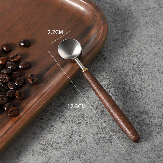 Kleiner Espresso-Löffel mit 2.2cm Edelstahlschale und Walnussholzgriff – perfekt für präzise Dosierungen.