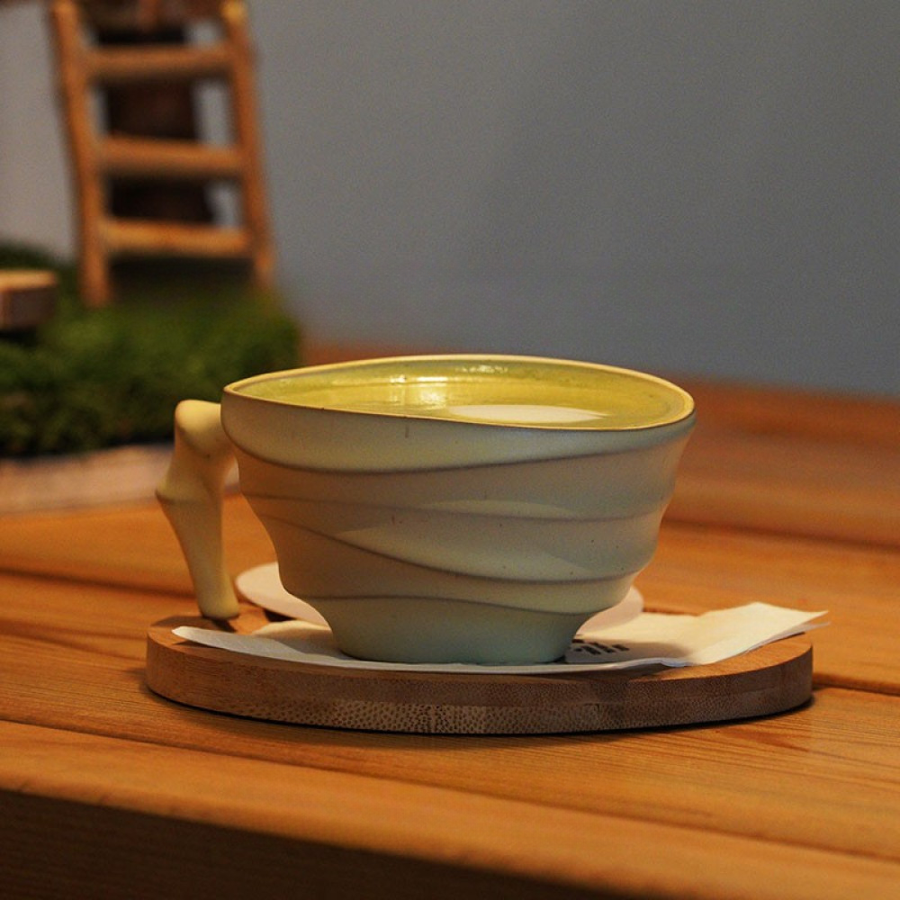 Beige Tasse mit dekorativem Henkel in Elefantenform auf Holztablett – schlicht, verspielt und hochwertig.
