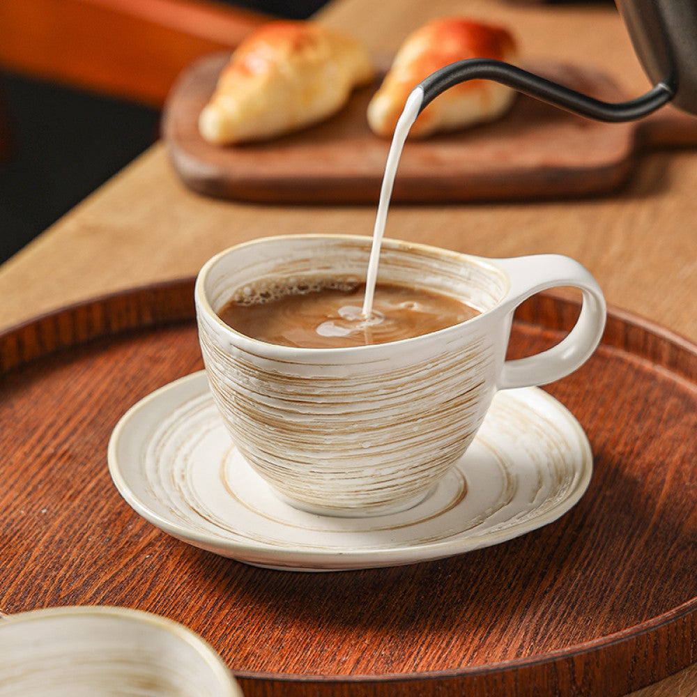 Heisses Wasser wird in eine beige Vintage-Keramiktasse gegossen – perfekte Szene für Kaffee- oder Teeliebhaber.