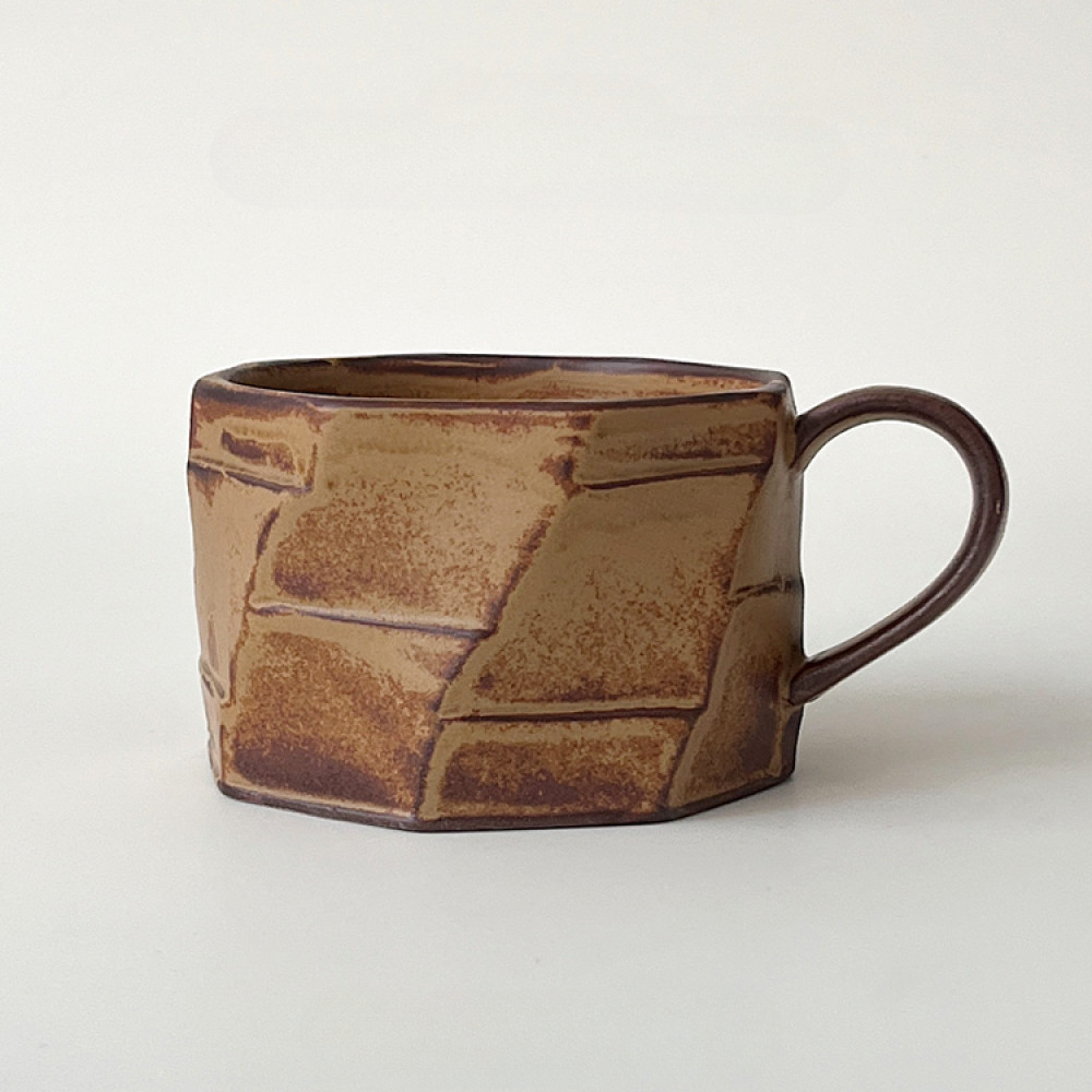Braune Tasse mit auffälliger Struktur und natürlichem Farbverlauf. Robust, rau und einzigartig.