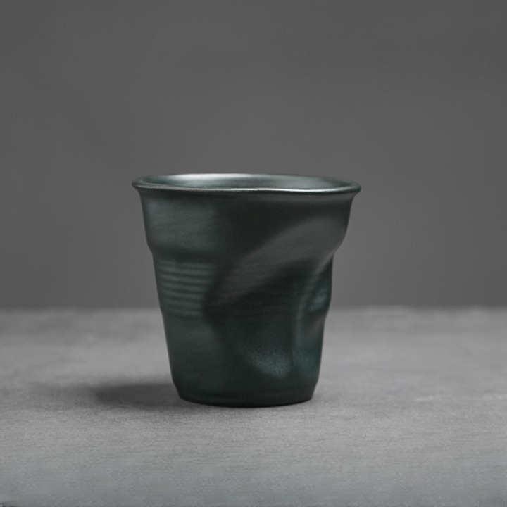 Dunkelgrüne Tasse aus Keramik mit charakteristischer Knickform. Elegant und ausdrucksstark.