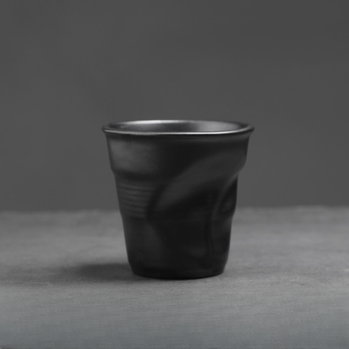 Mattschwarze Keramiktasse mit weicher Knickstruktur. Zeitgemässes Design für Espresso oder Cappuccino.