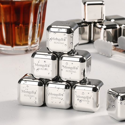 Sechs glänzende Edelstahl-Eiswürfel gestapelt vor einem Getränk – rostfrei, geschmacksneutral und ideal für Drinks.