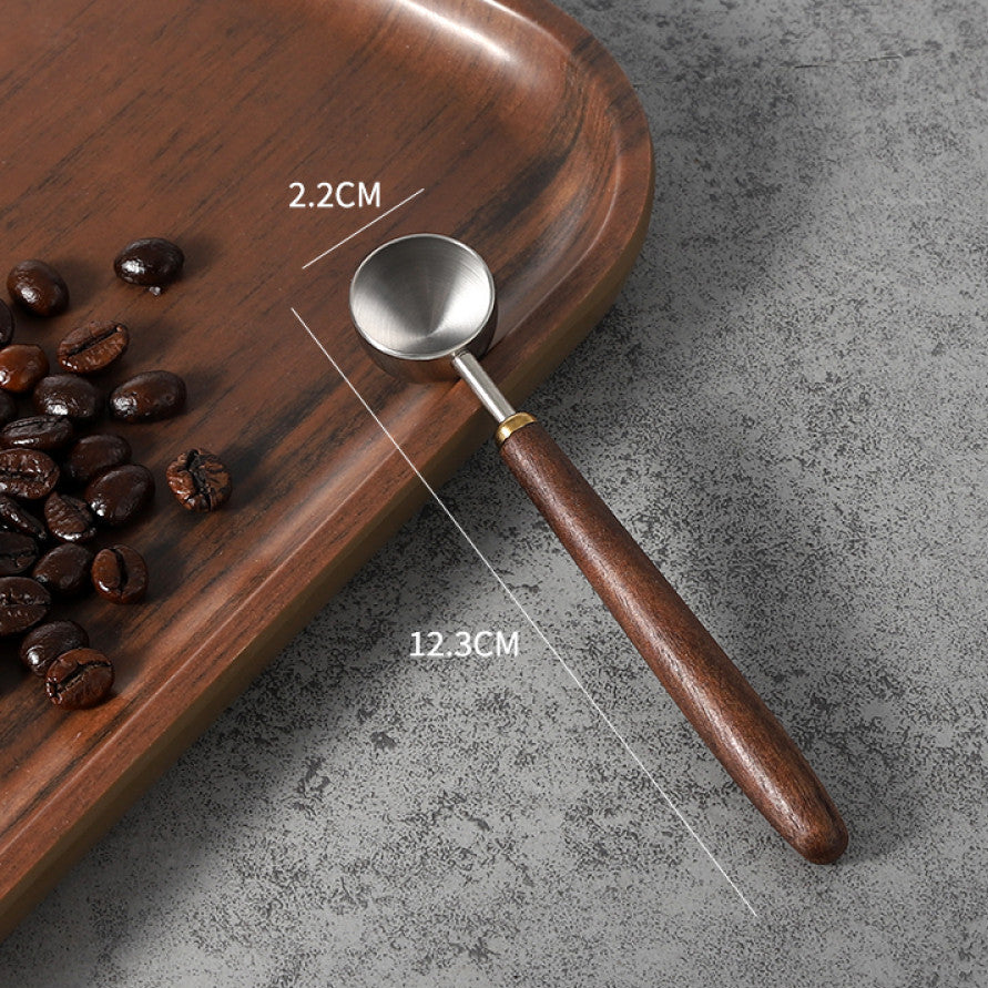 Kleiner Espresso-Löffel mit 2.2cm Edelstahlschale und Walnussholzgriff – perfekt für präzise Dosierungen.