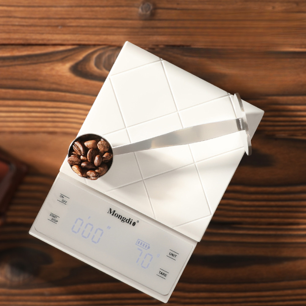 Der multifunktionale Edelstahl-Löffel mit integriertem Tamper liegt auf einer Digitalwaage – für exakte Kaffeezubereitung.