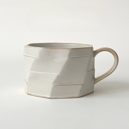 Beige Tasse mit plastischer Struktur auf hellem Hintergrund. Handgefertigtes Einzelstück in minimalistischem Look.