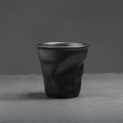 Mattschwarze Keramiktasse mit weicher Knickstruktur. Zeitgemässes Design für Espresso oder Cappuccino.