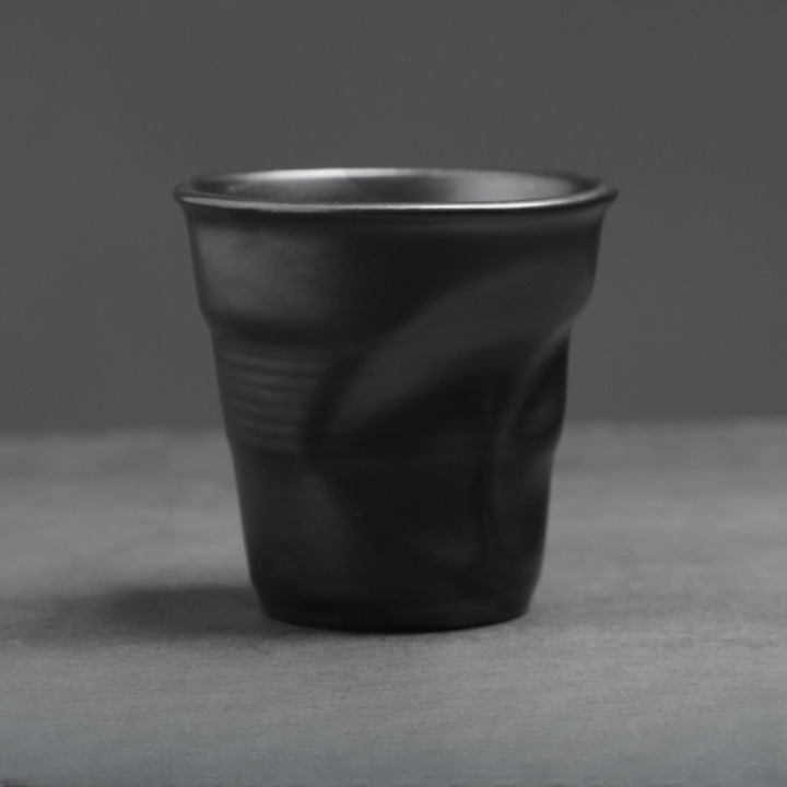 Runde schwarze Keramiktasse mit charakteristischer Knickung. Kombiniert Handwerkslook mit moderner Ästhetik.