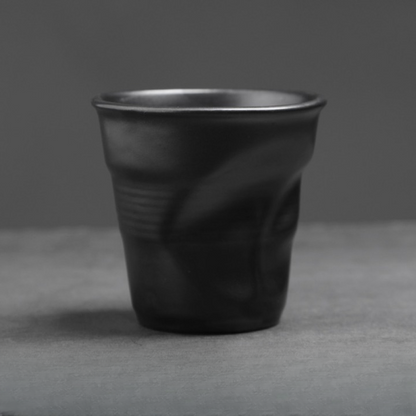 Runde schwarze Keramiktasse mit charakteristischer Knickung. Kombiniert Handwerkslook mit moderner Ästhetik.