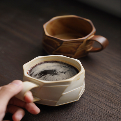 Zwei strukturierte Tassen mit frisch gebrühtem Kaffee, auf dunklem Tisch. Authentisches, modernes Design.